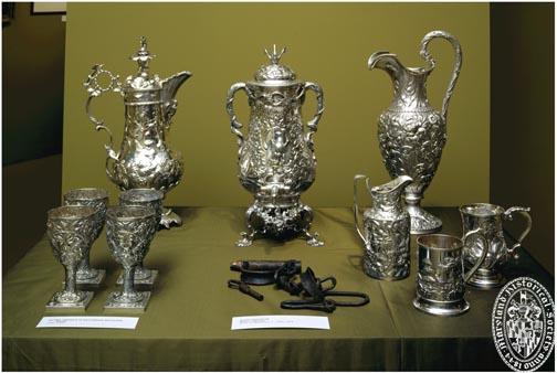 Display case containing fine silverware and slave shackles